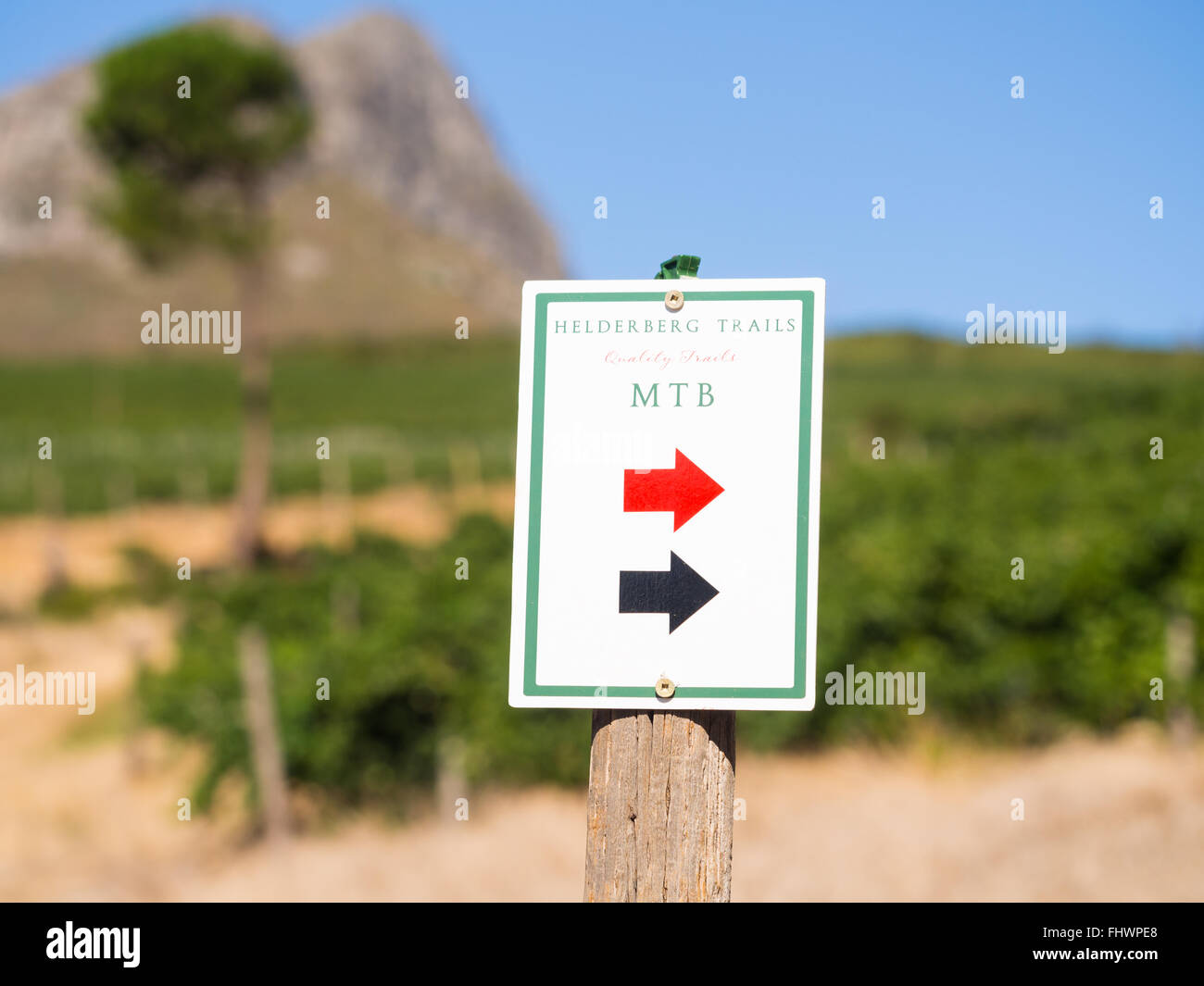 Segno che mostra la via per il rosso e il nero sentieri nel Helderberg Riserva Naturale in Sud Africa. Vigneti in background. Foto Stock