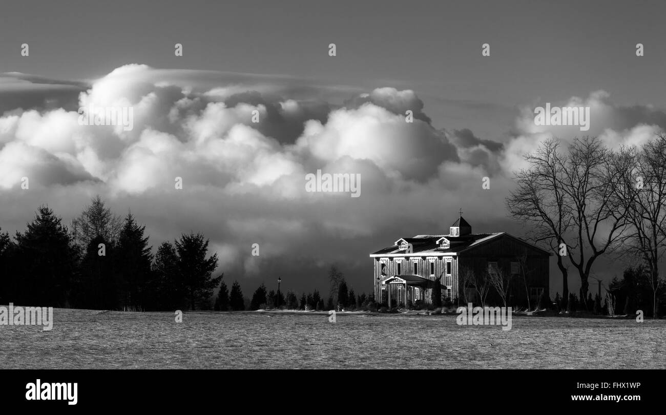Central Elgin, Canada. Una casa nelle zone rurali del sudovest Ontario Canada si trova in inizio di mattina di luce con una grande nuvola formazione beh Foto Stock