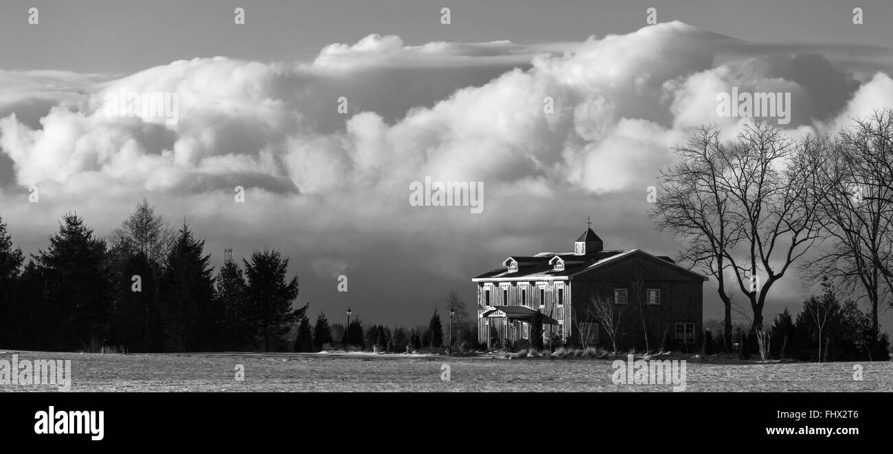 Central Elgin, Canada. Una casa nelle zone rurali del sudovest Ontario Canada si trova in inizio di mattina di luce con una grande nuvola formazione beh Foto Stock