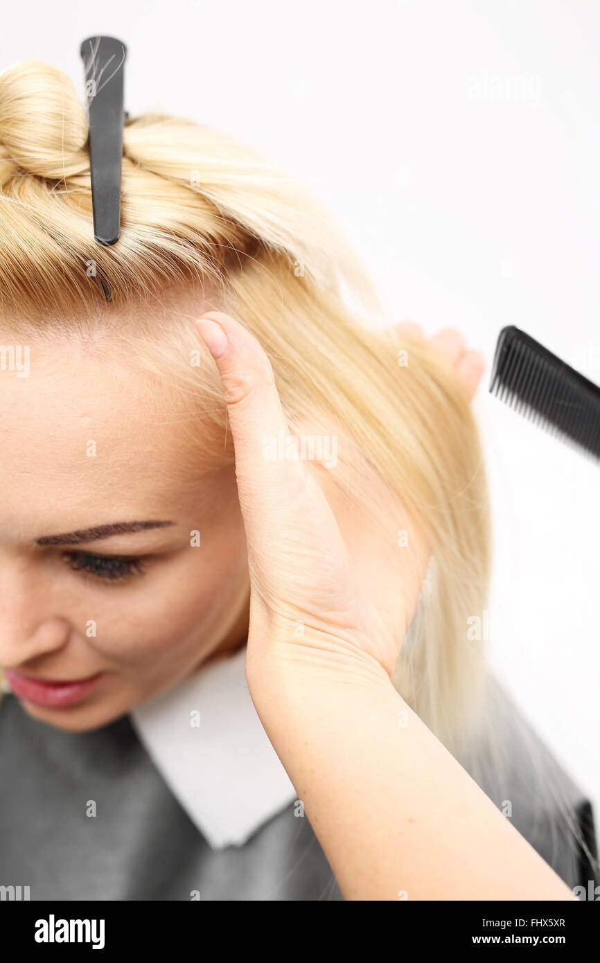 La pettinatura dei capelli. La donna in sedia barbiere styling durante la chirurgia. Parrucchiere Parrucchiere donna pettinatura Foto Stock