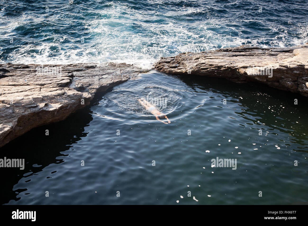 Vista superiore della donna nuoto nella piscina con acqua di mare naturale piscina. Foto Stock