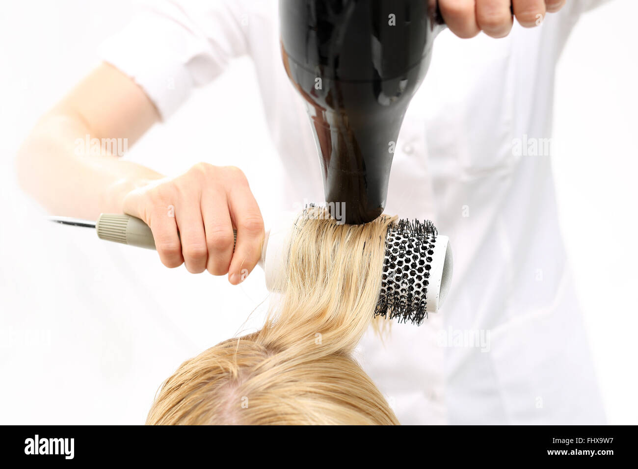 Pettinare i capelli a spazzola di essiccazione. La donna presso il parrucchiere, barbiere modelli capelli su una spazzola circolare. Parrucchiere capelli secchi Foto Stock