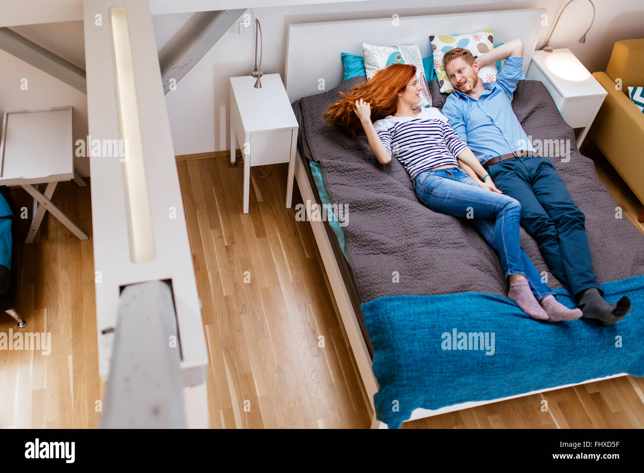 Bella giovane in appoggio sul letto in un moderno appartamento Foto Stock