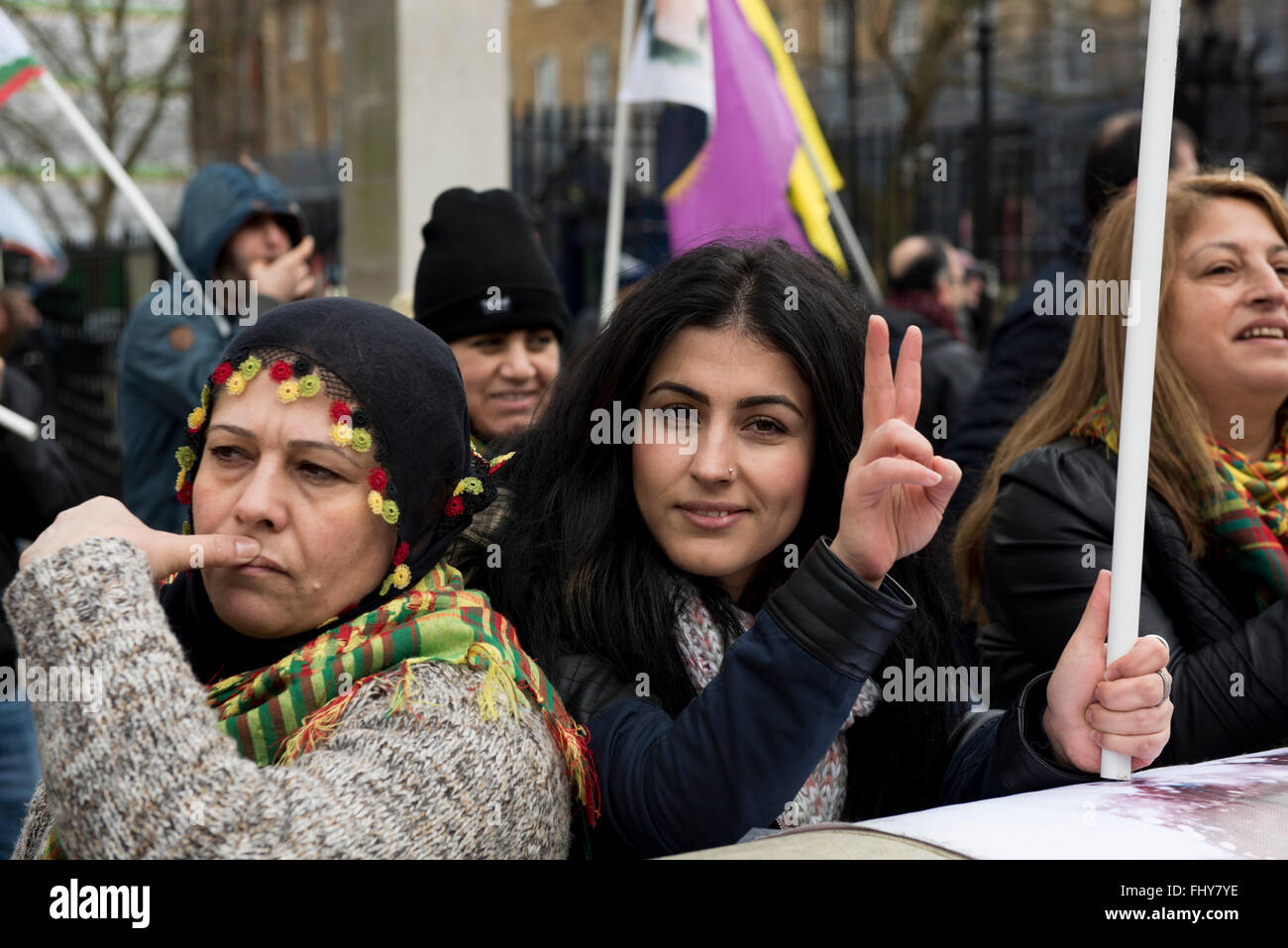 Una giovane donna curda lampeggio di un segno di pace durante la dimostrazione curdo al di fuori di Downing Street, Londra, Regno Unito. Foto Stock