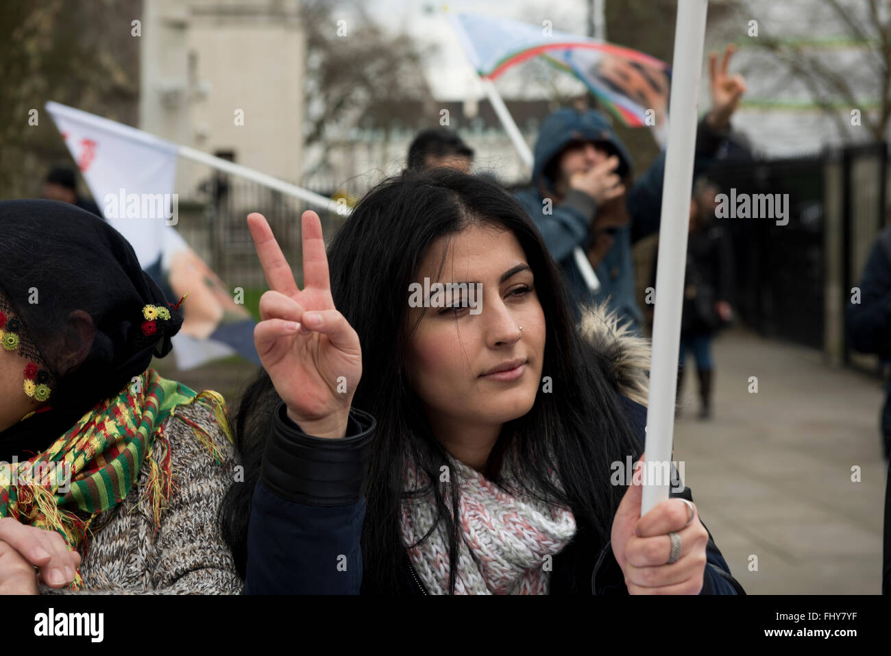 Una giovane donna curda lampeggia un segno di pace durante la dimostrazione curdo al di fuori di Downing Street, Londra, Regno Unito. Foto Stock