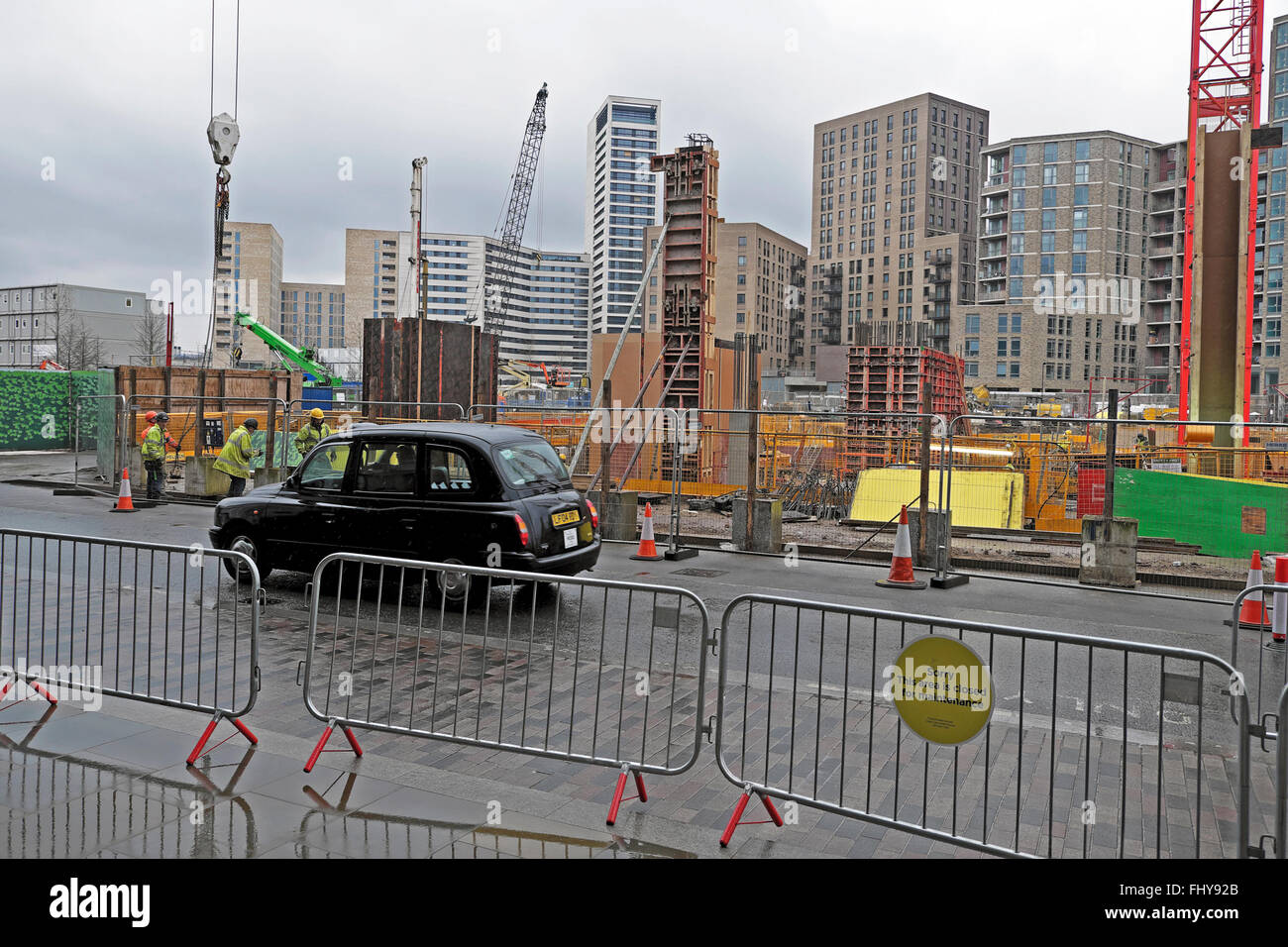 Alto edificio torre residenziale blocchi, gru sul skyline & taxi dalla costruzione di abitazioni sul sito Handyside Street a Kings Cross Londra di sviluppo N1C UK Foto Stock
