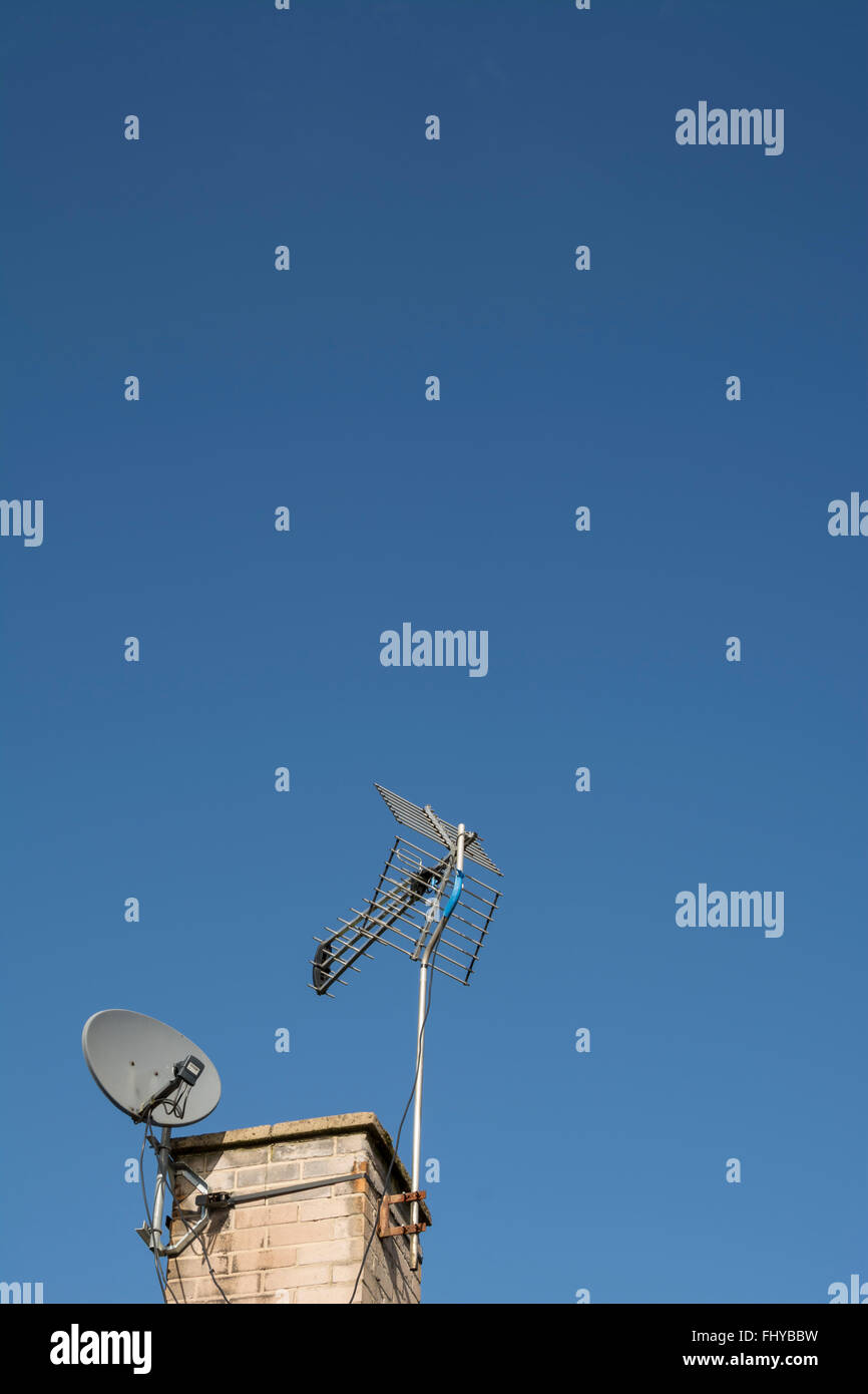 Antenna TV digitale e satellitare su un camino contro un cielo blu. Foto Stock
