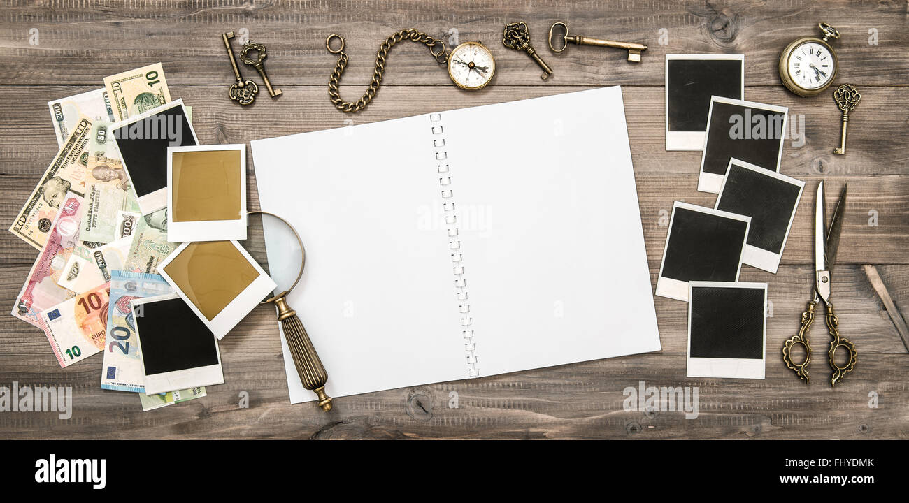 Diario di viaggio prenota, polaroid photo frame, bussola, chiavi, denaro contante in valuta diverse banconote Foto Stock