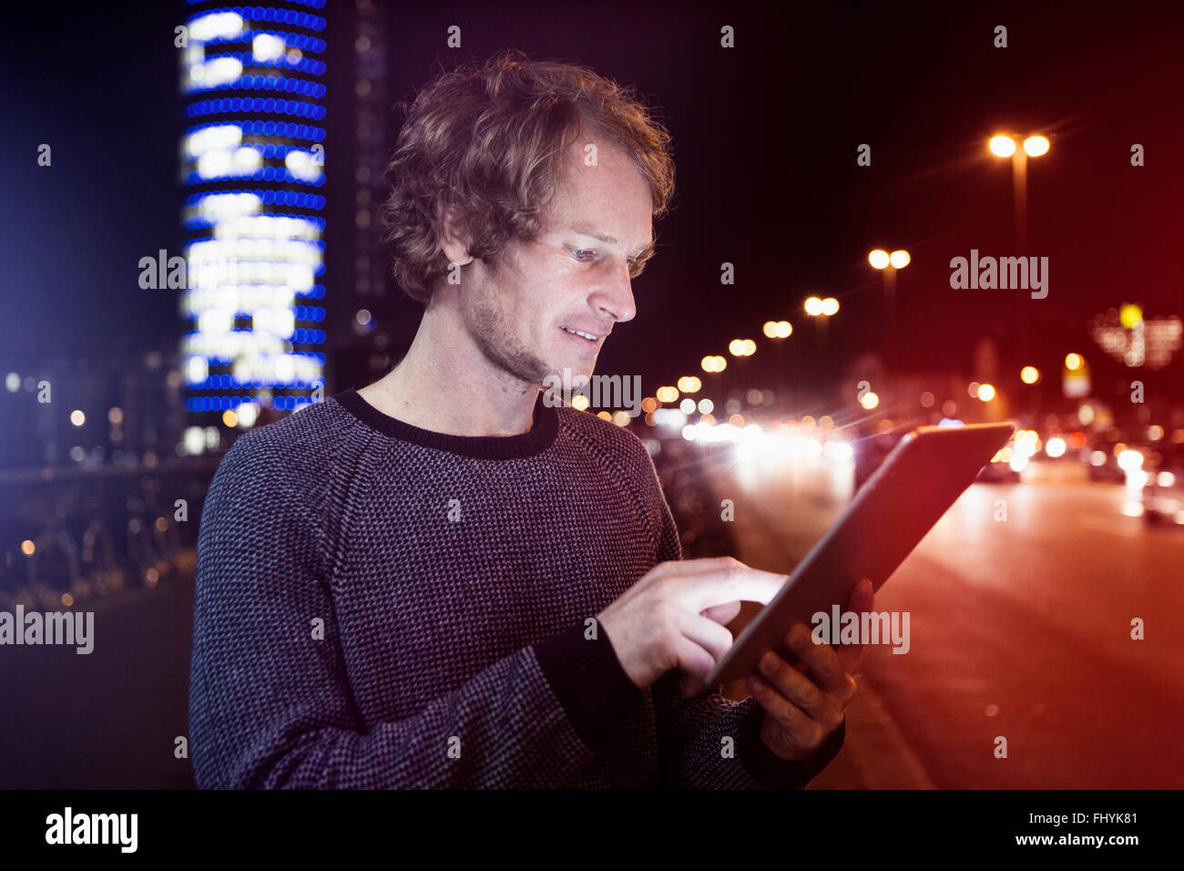 Germania - Monaco, ritratto di uomo con tavoletta digitale di notte Foto Stock