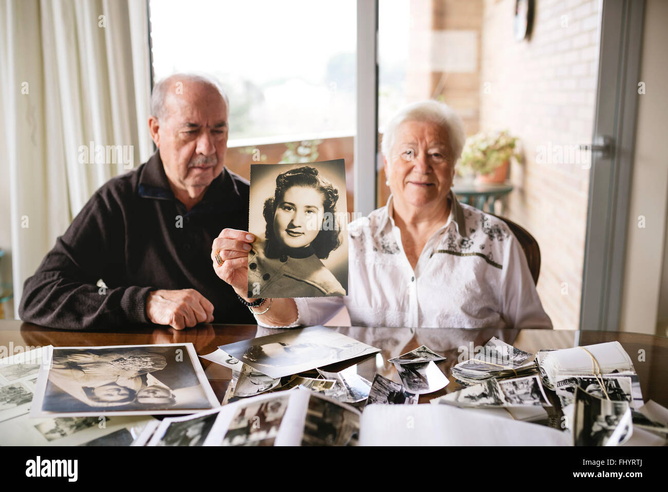 Senior donna che mostra una vecchia foto di se stessa Foto Stock