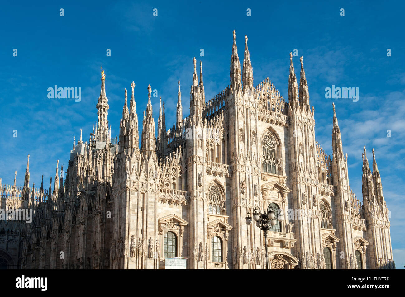 Lato anteriore del Duomo di Milano sotto il cielo blu Foto Stock
