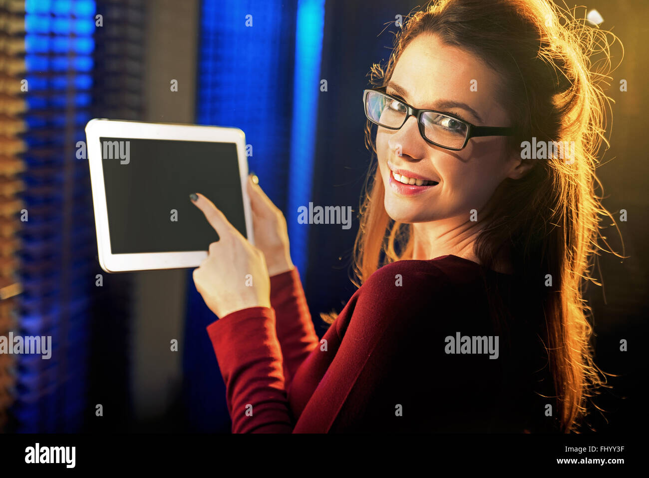 Affascinante signora giovane puntando una compressa Foto Stock