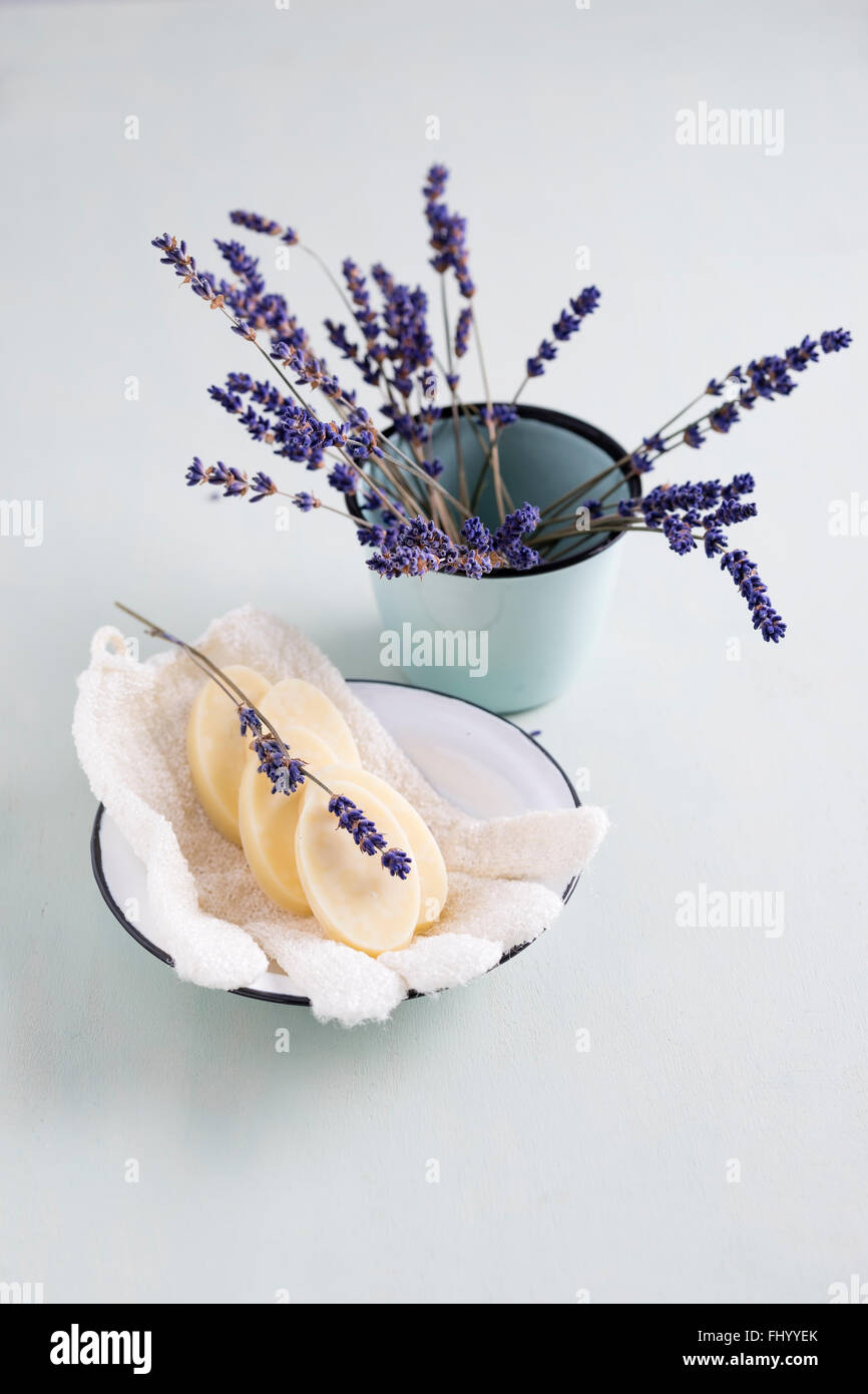 Vasca da bagno praline nella ciotola con lavanda e Guanto massaggio Foto Stock
