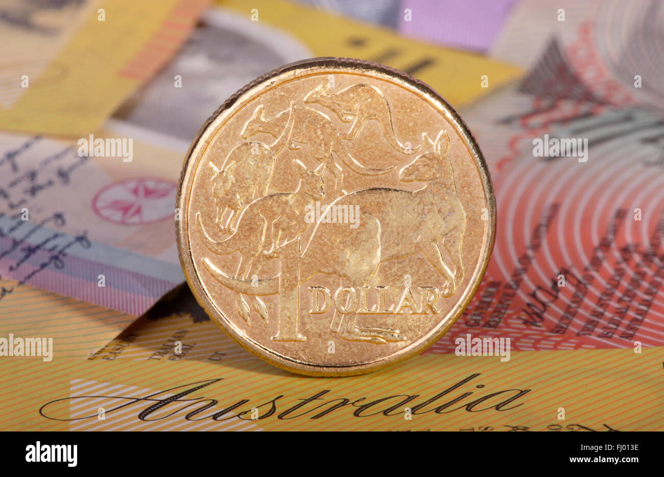 Un dollaro australiano moneta con uno sfondo di banca australiana note. Foto Stock