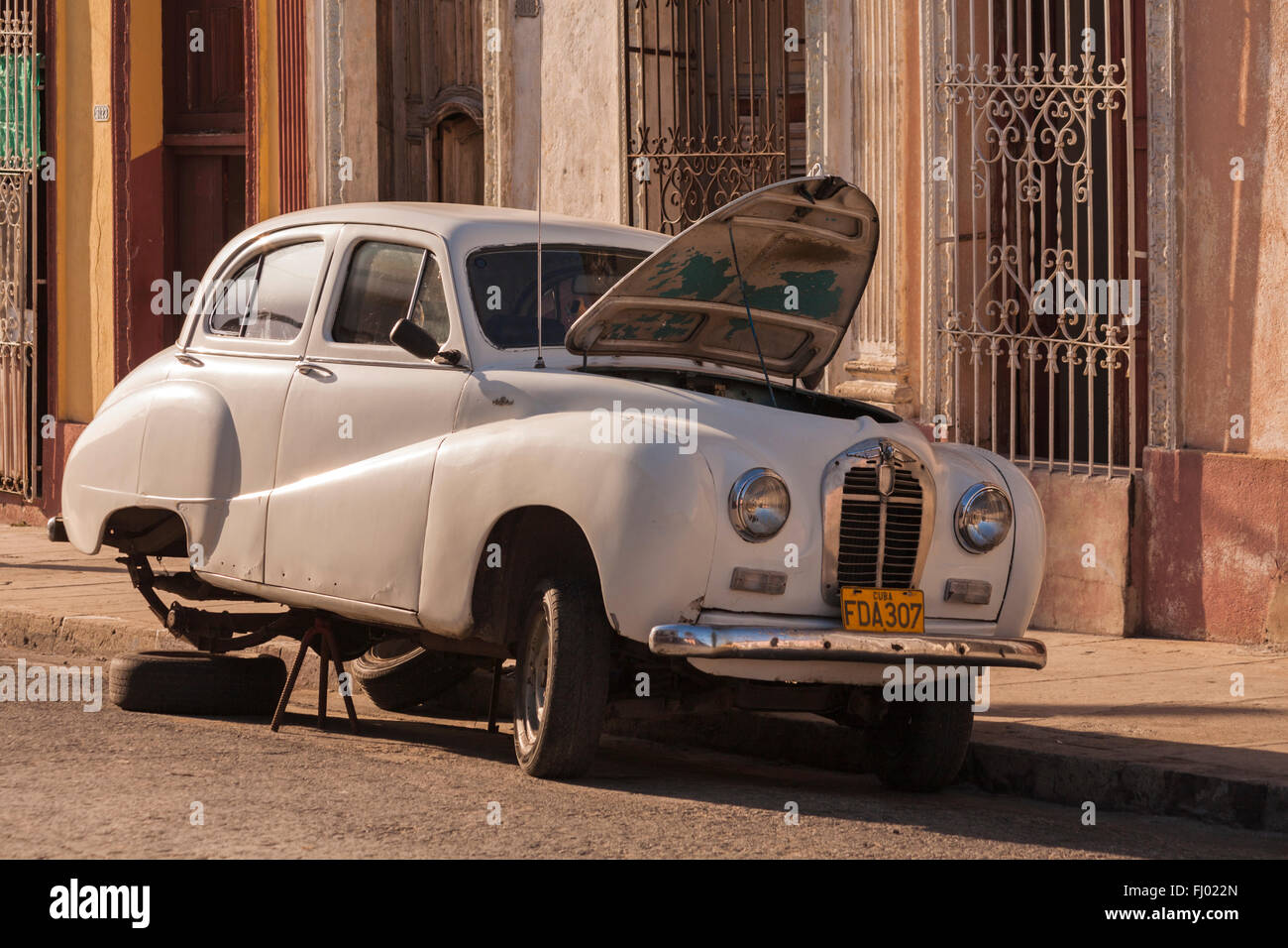 Vecchia auto sollevato con ruote posteriori rimossi e il cofano fino in strada a l'Avana, Cuba, West Indies, dei Caraibi e America centrale Foto Stock
