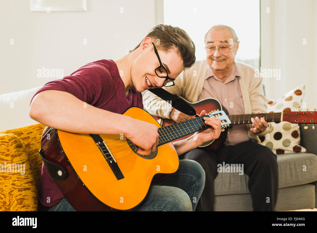 Nonno e nipote a suonare la chitarra insieme Foto Stock