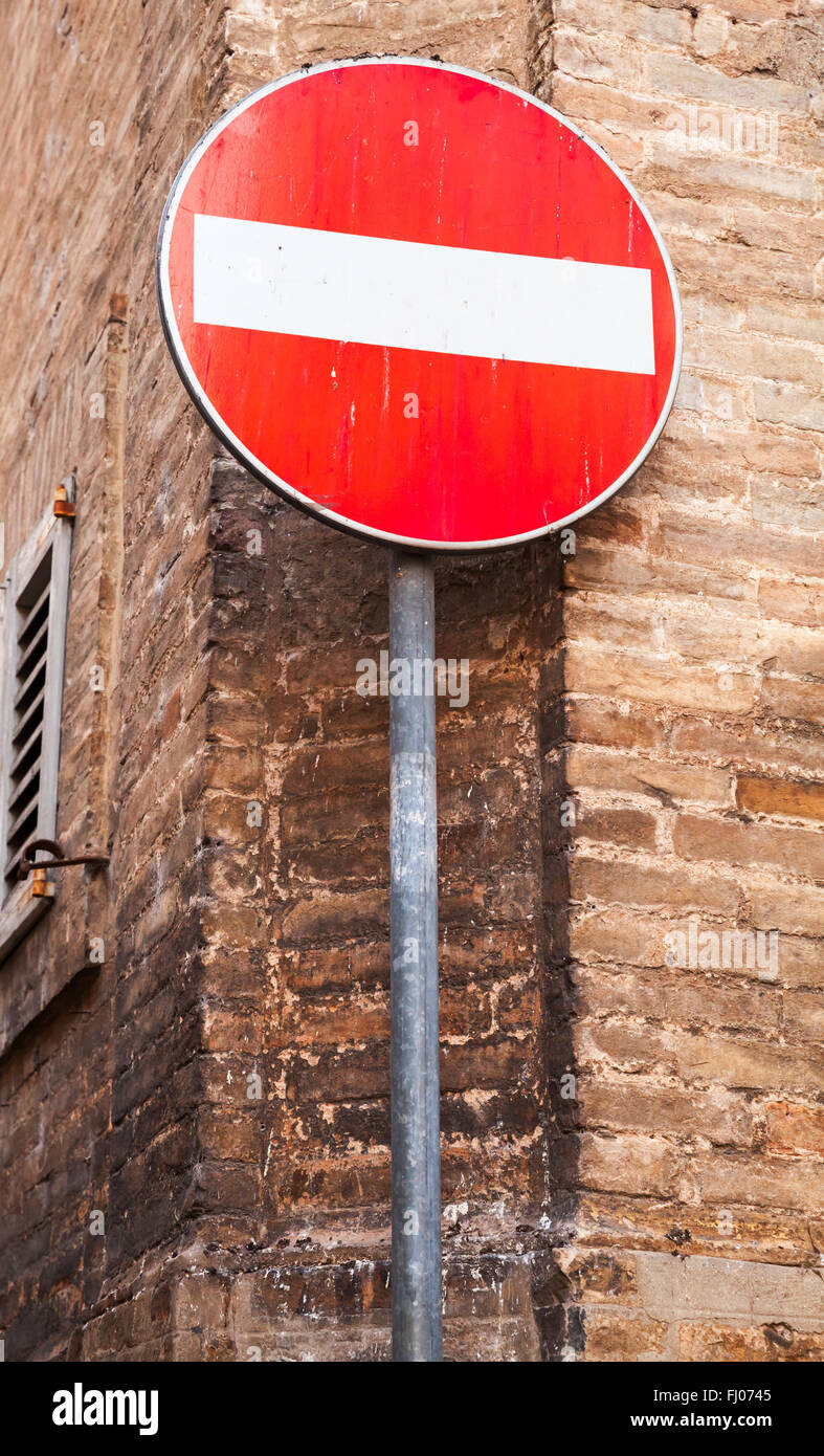 Round segno rosso Nessuna voce sul palo metallico vicino al vecchio muro di mattoni Foto Stock