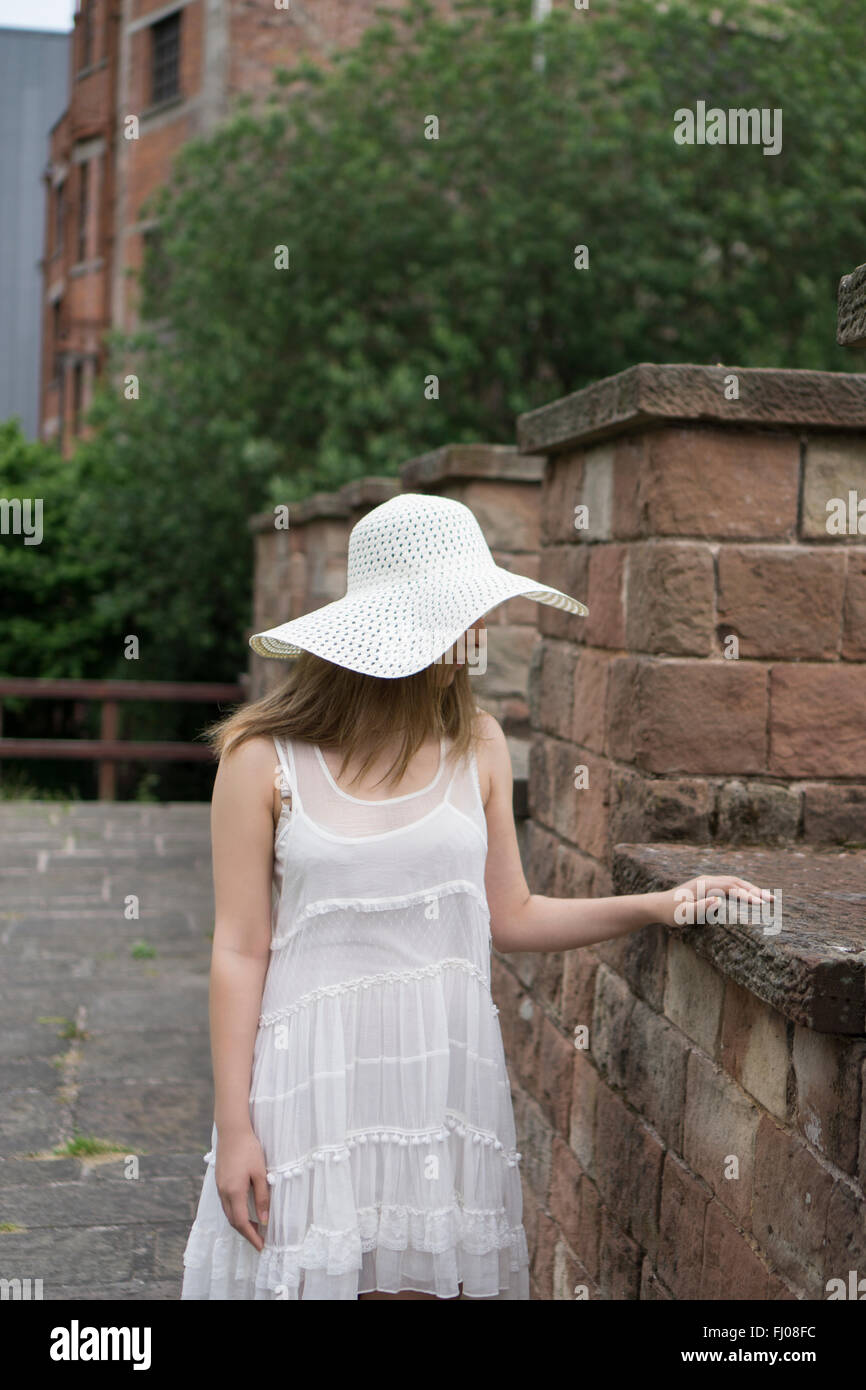 Lonely ragazza in un abito bianco in piedi all'aperto Foto Stock