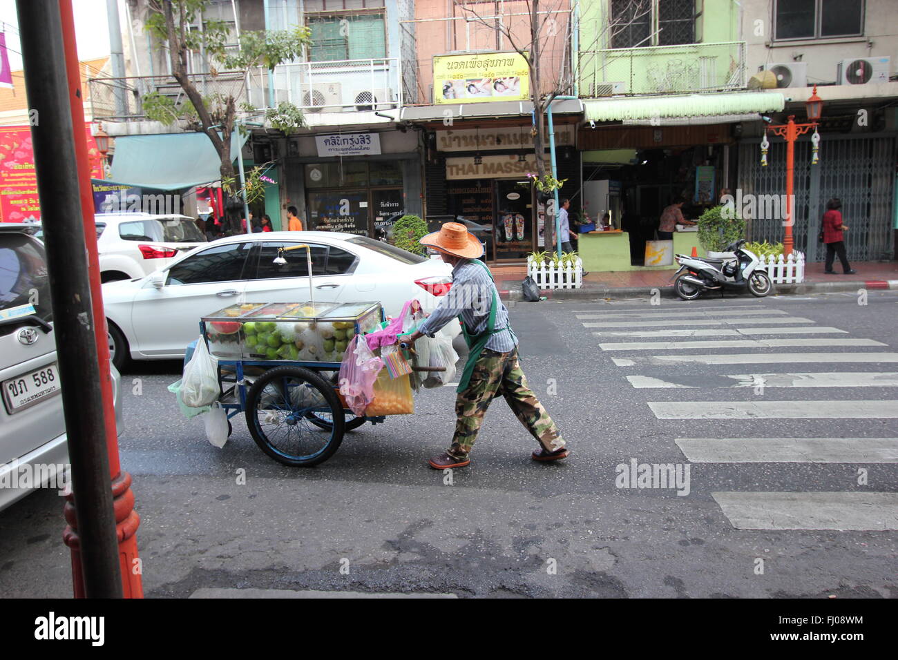 Un uomo spinge un carrello pieno di shopping in, China Town, Bangkok, Thailandia Foto Stock