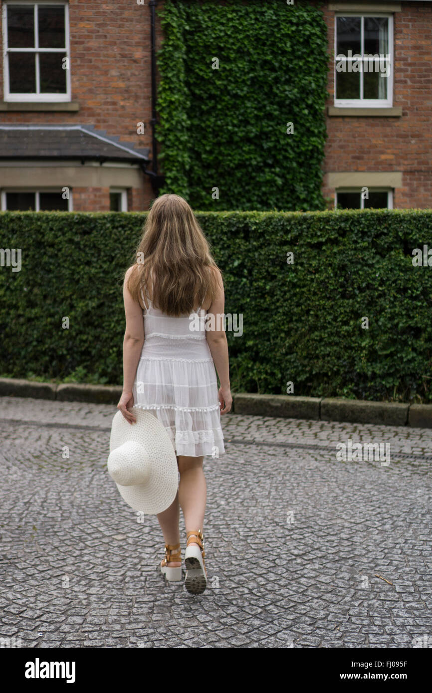 Donna che cammina home Foto Stock