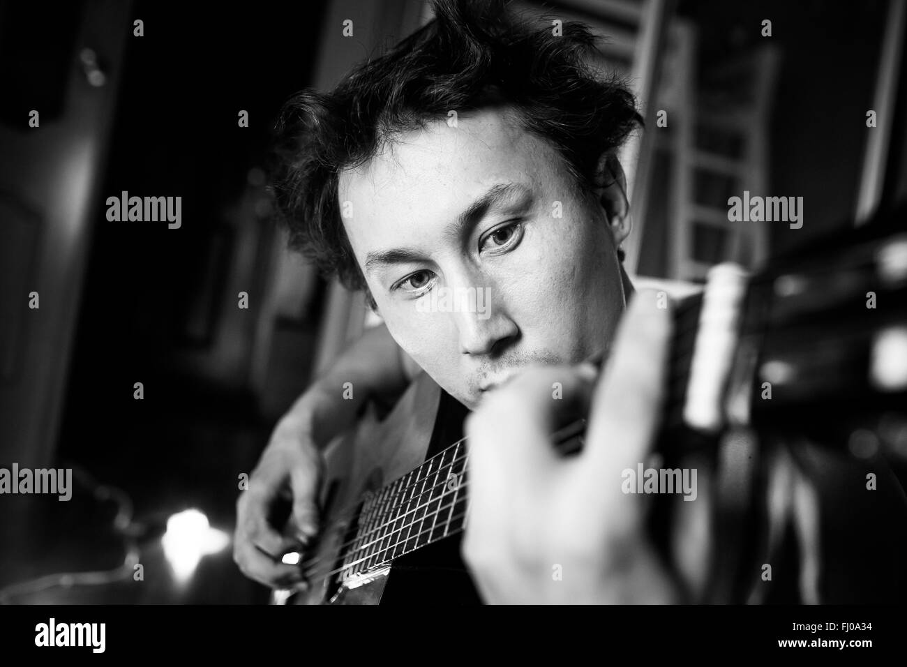 Crazy appassionato chitarrista suonando la chitarra, in bianco e nero di close-up verticale. Musicista con capelli disheveled. Foto Stock