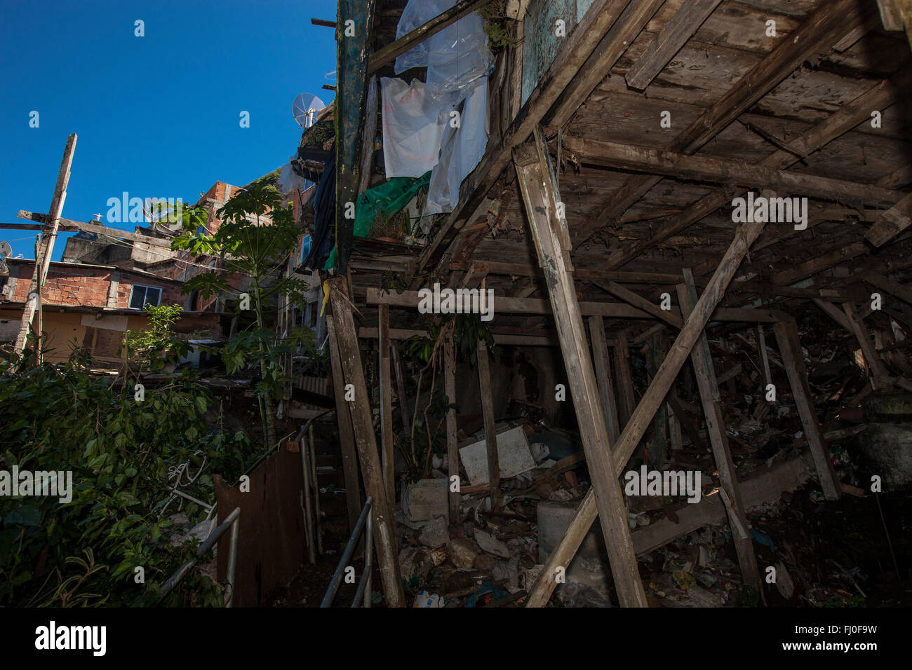 Precaria in legno palafitta in favela di Santa Marta, Rio de Janeiro, Brasile - Cristo Redentore statua in background. Foto Stock