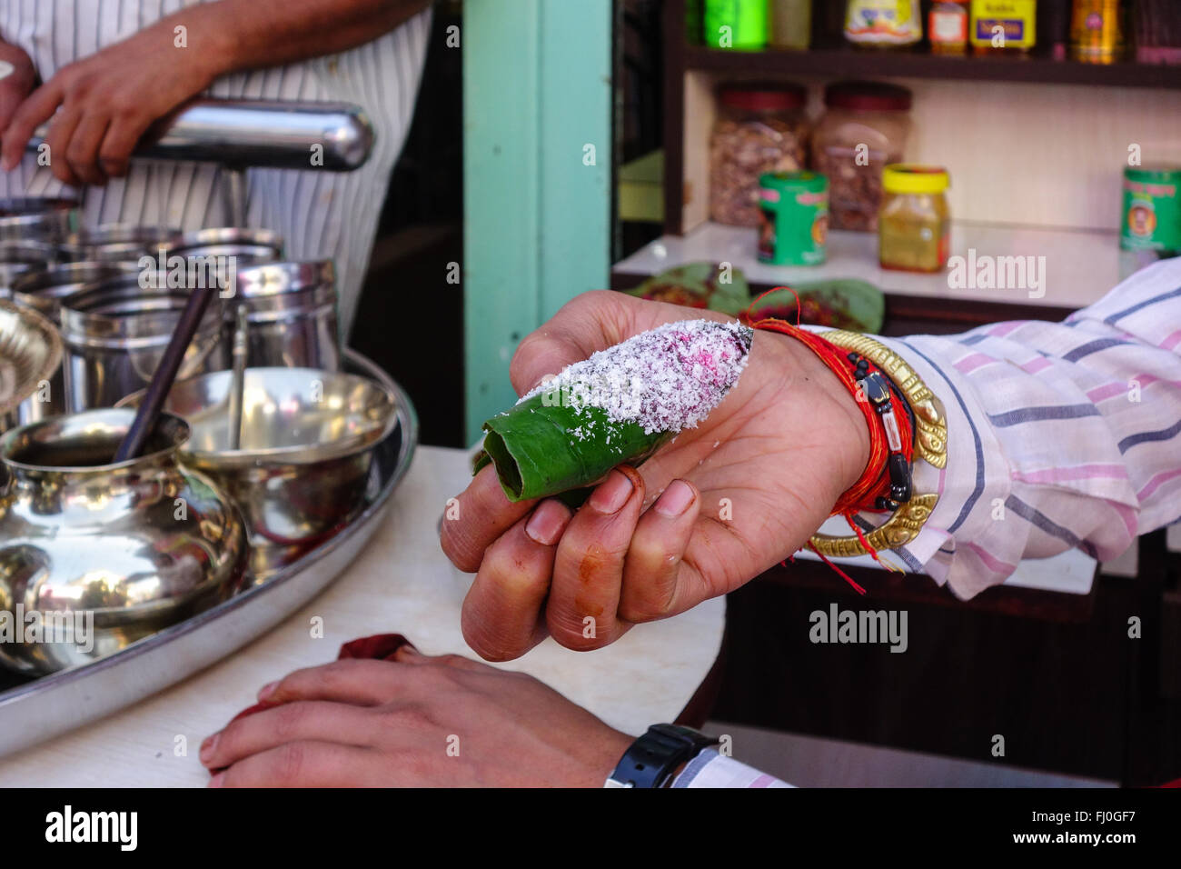 Strada paanwala dando dolci preparati paan ( meetha paan ) per il cliente. Foto Stock