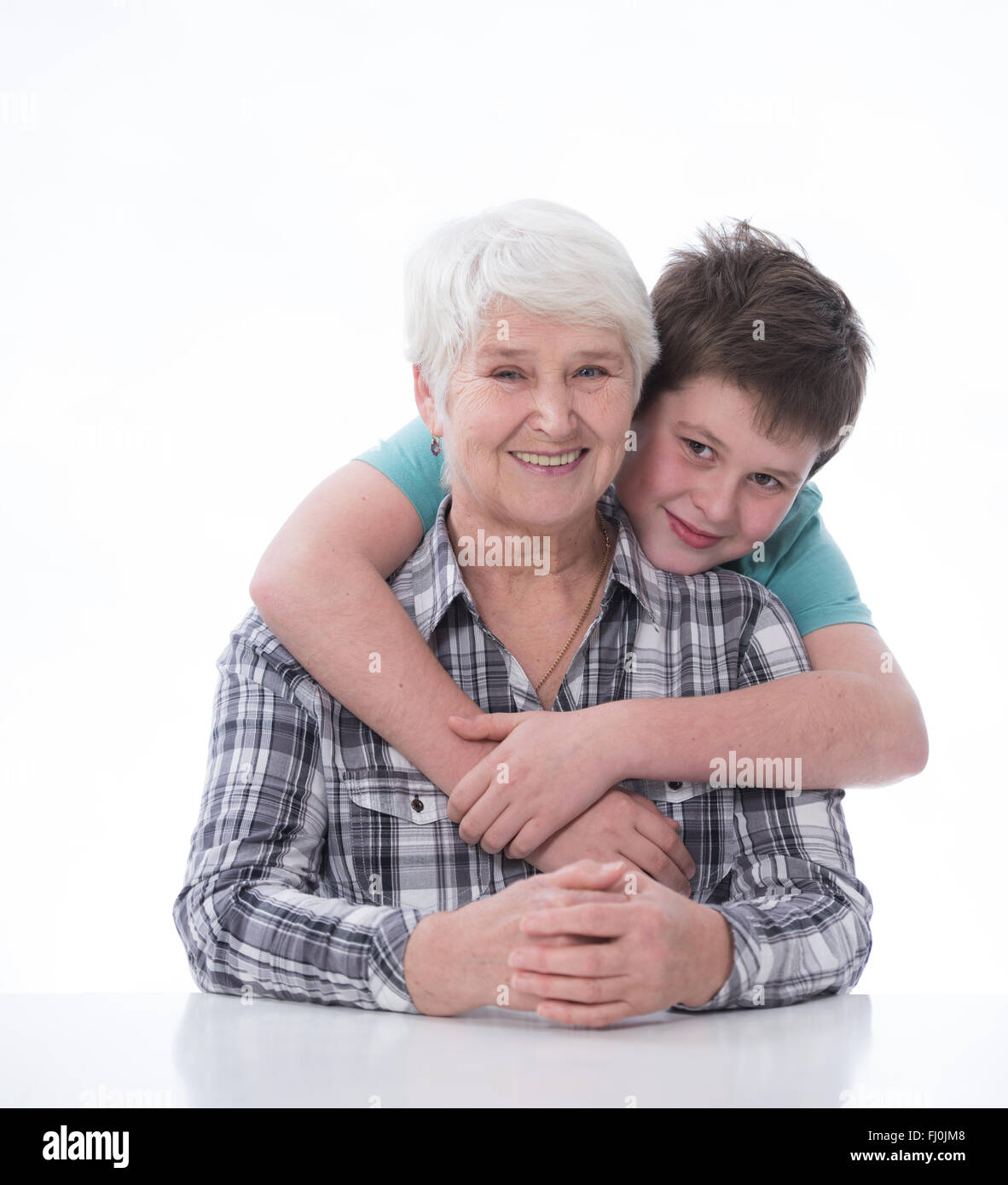 Ragazzo giovane con donna anziana, sorridente, avvolgente Foto Stock