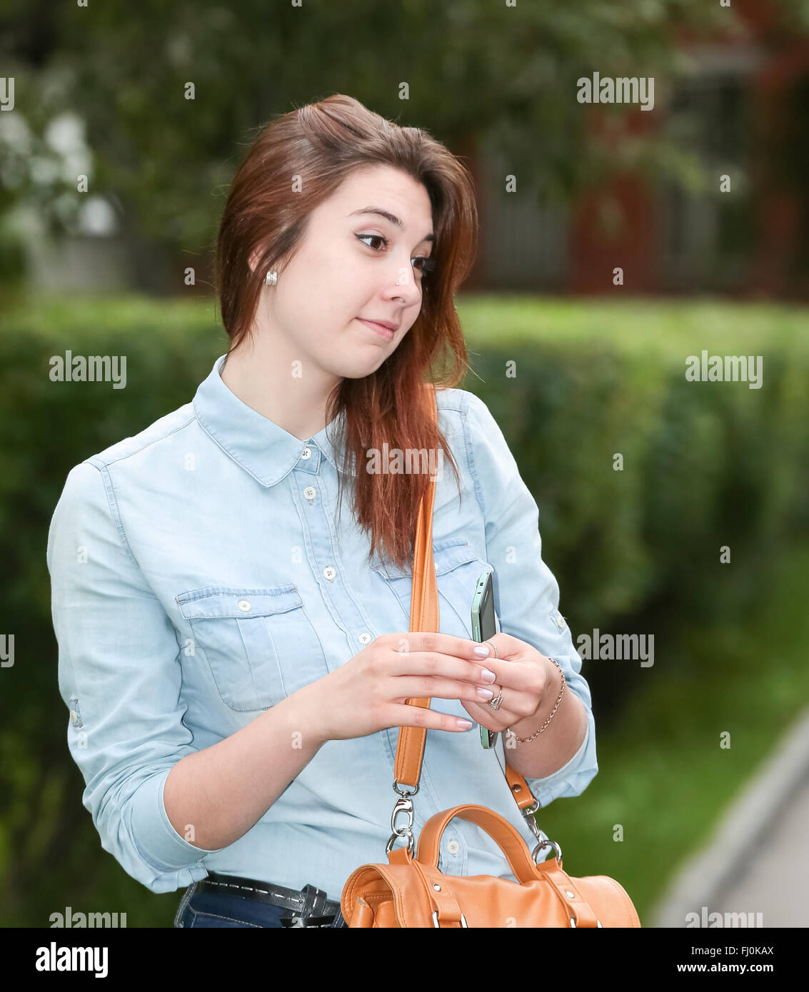 Una studentessa si appoggia al Parco dopo la scuola. Foto Stock