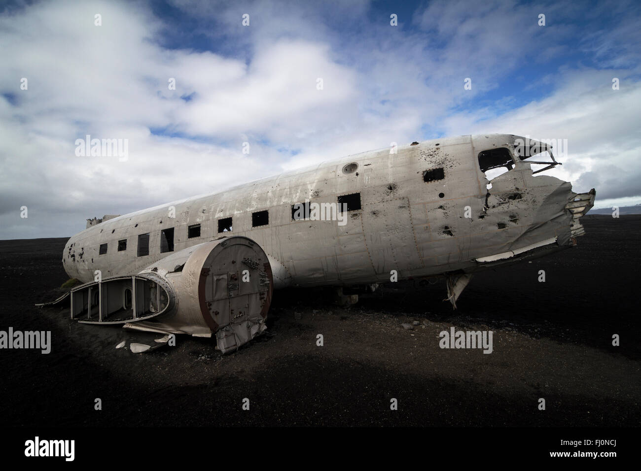 Il lato orizzontale vista di un relitto aereo sulle sabbie nere e sullo sfondo di un cielo blu nel sud dell'Islanda Foto Stock