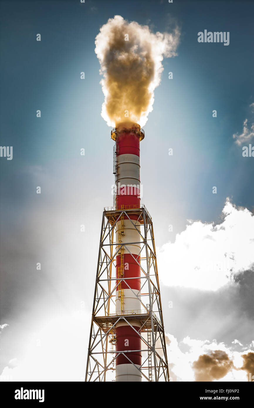 Inquinamento Ambientale - tubazione industriale con fumo su uno sfondo con cielo. Foto Stock