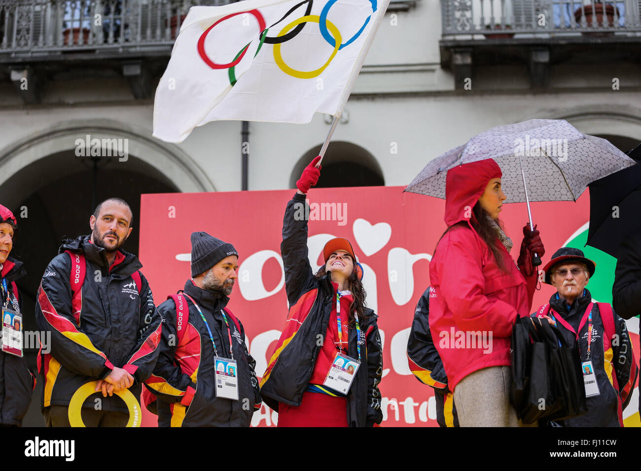 Torino, Italia. Il 27 febbraio, 2016. Un volontario sventola la bandiera con anelli olimpici durante la celebrazione del decimo anniversario del Torino XX Giochi Olimpici Invernali. Credito: Elena Aquila/Pacific Press/Alamy Live News Foto Stock