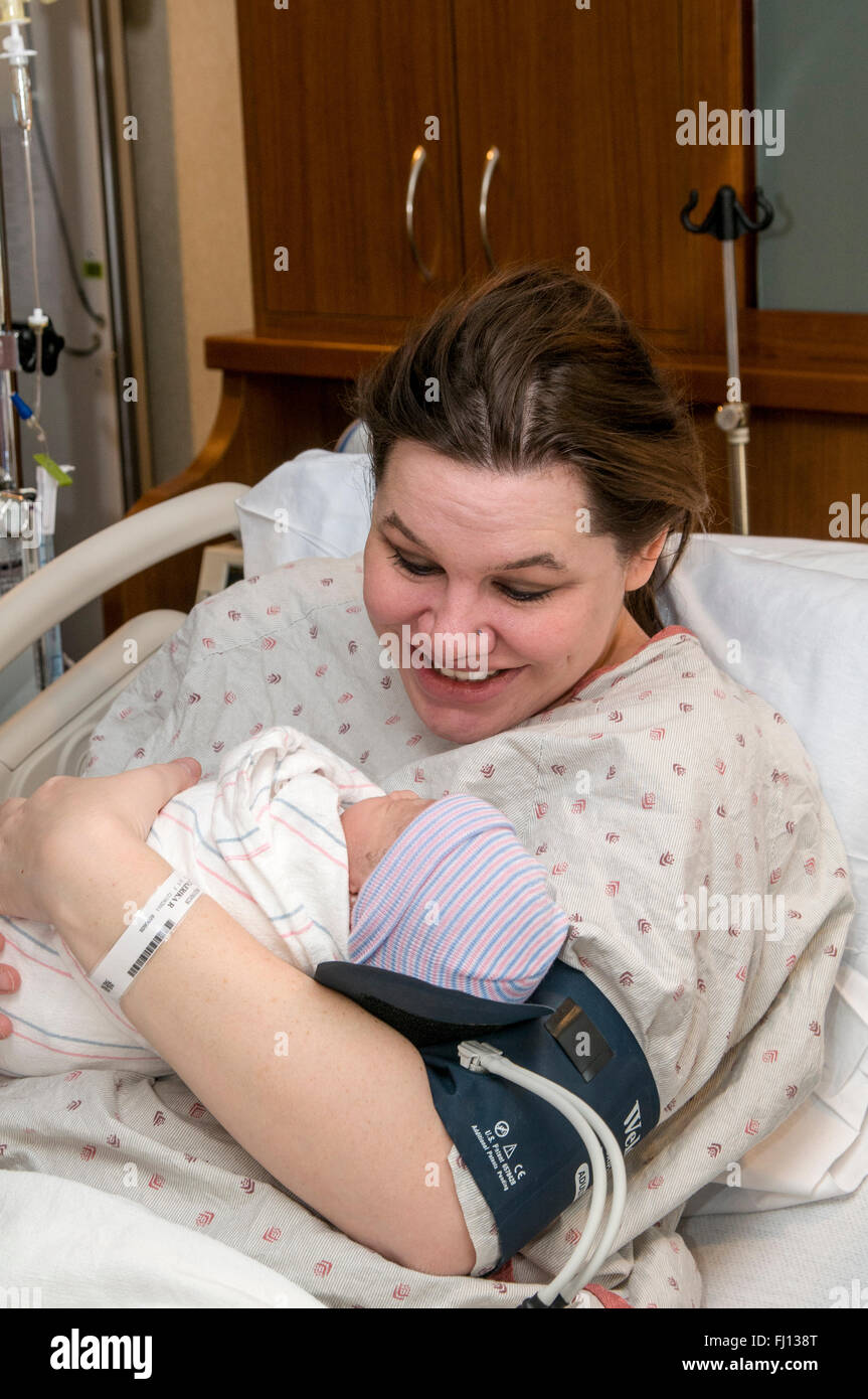 Fridley, Minnesota. Unità ospedale. 31 anni single mom con incollaggio neonato bi-razziale bambina in ospedale. Foto Stock