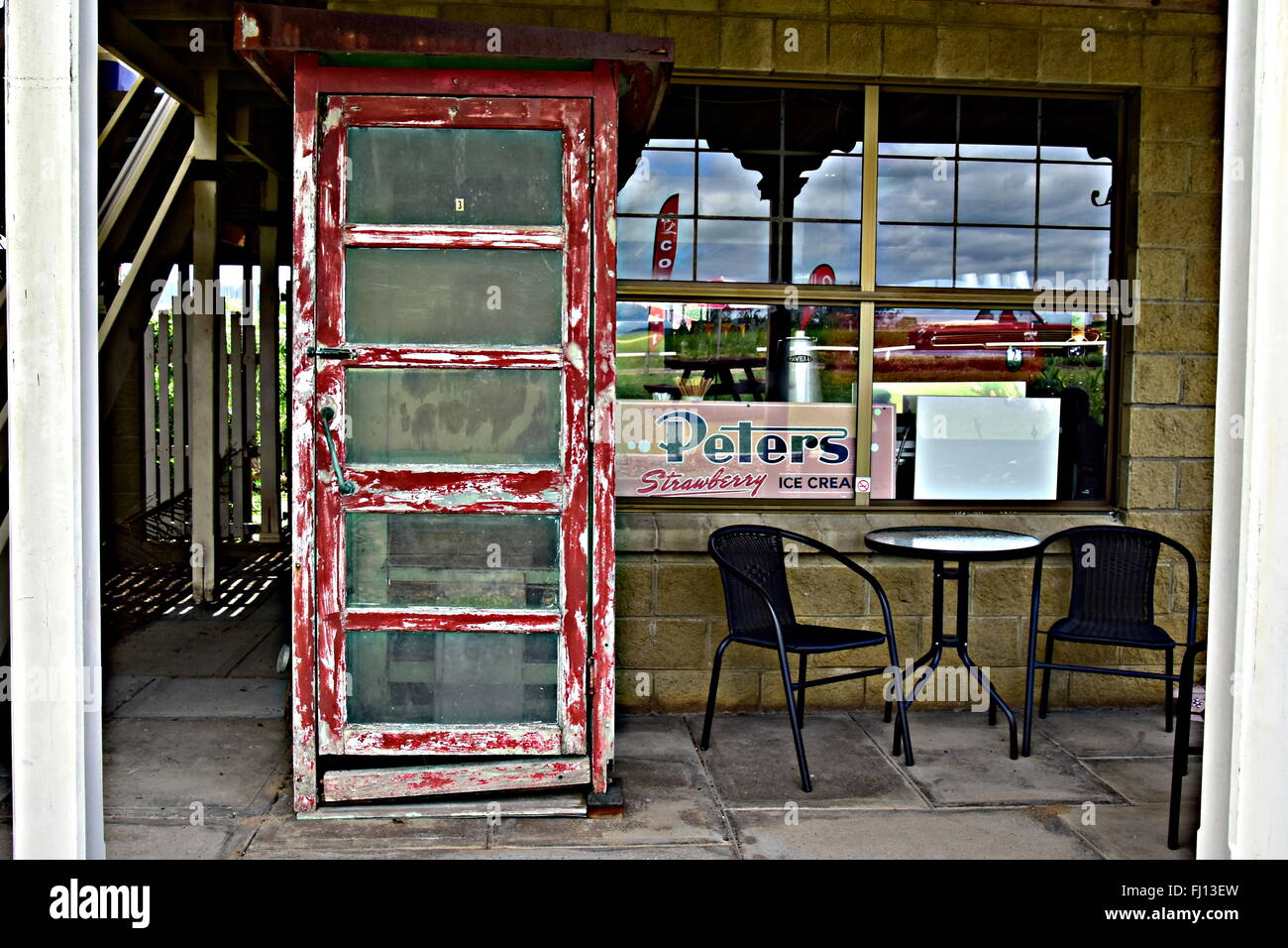 VECCHIO TELEFONO ROSSO DAVANTI AL CAFE Foto Stock