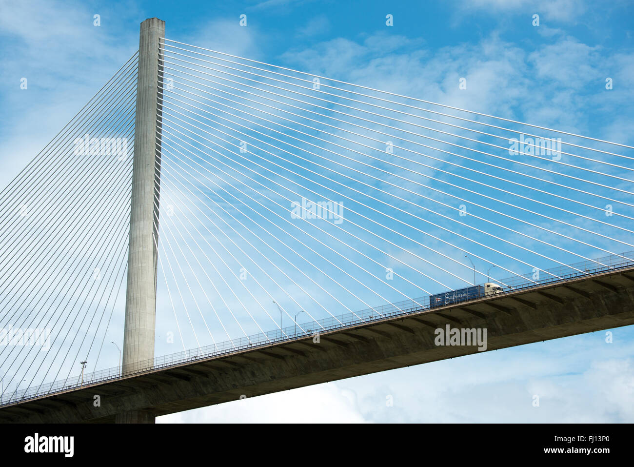 Centennial Bridge Panama City Panama | PANAMA CITY, Panama — Un trattore rimorchio attraversa il Centennial Bridge sopra il canale di Panama, i suoi due piloni in cemento si innalzano per circa 604 piedi (184 m) sopra il Gaillard Cut vicino alle chiuse di Pedro Miguel. Completata nel 2004 per celebrare il centenario della Repubblica di Panama, la struttura a cavi sospesi ha alleviato decenni di congestione sull’anziana Bridge of the Americas, l’unica attraversamento stradale fisso del canale per quattro decenni. Essa costituisce un collegamento critico nella rete stradale che collega il Nord e il Sud America. Foto Stock