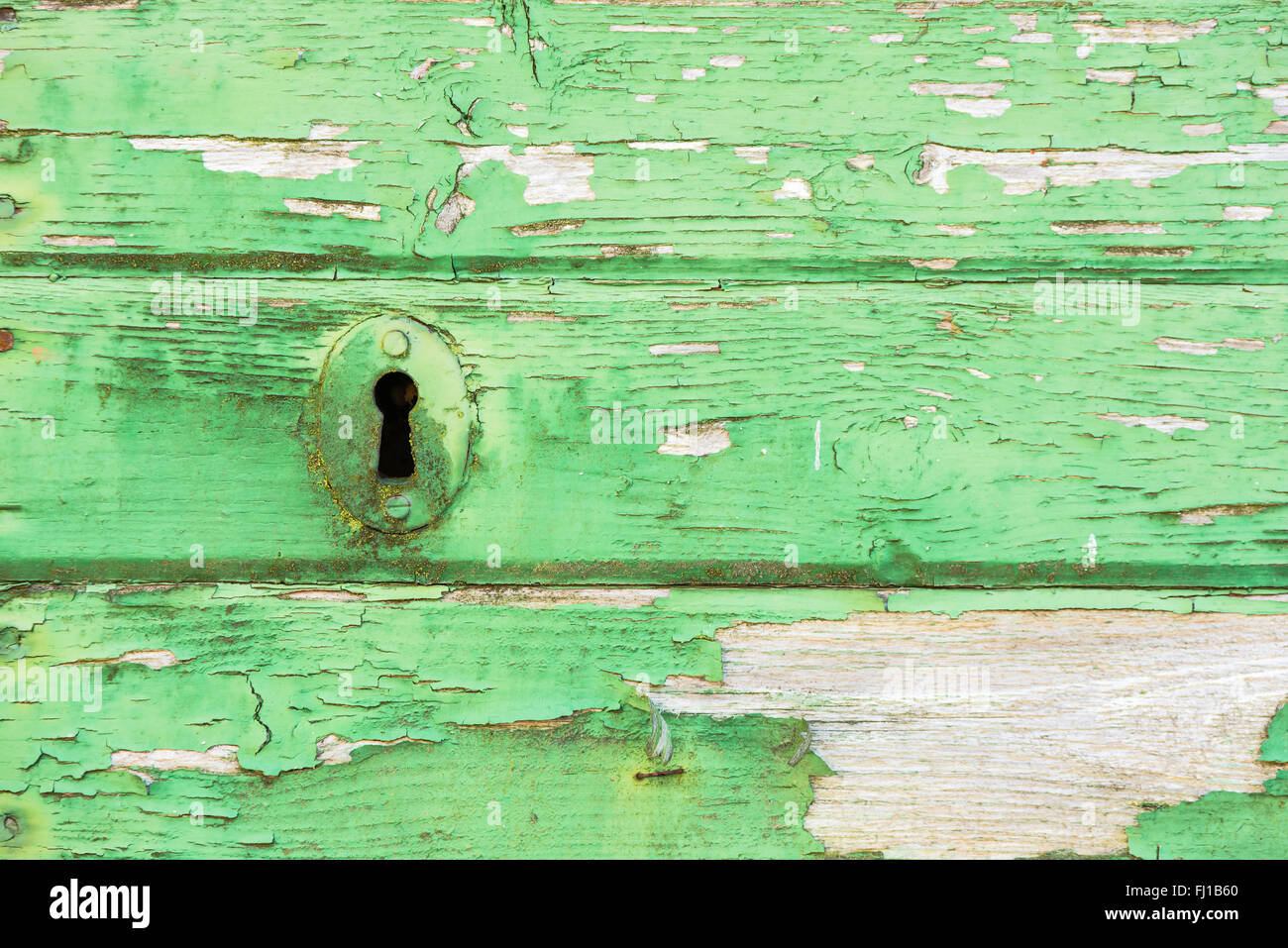 Close up dettaglio di una toppa di chiave su un dipinto di verde porta, weathered e nodose da tempo e condizioni difficili. Copia spazio sulla porta. Foto Stock