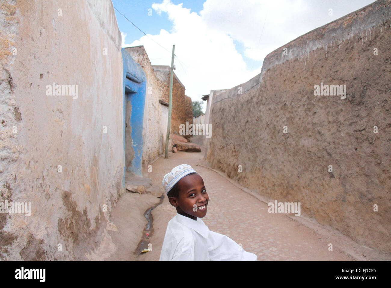 Un sorridente ragazzo musulmano passeggiate nella città vecchia di Harar , Etiopia , con la sua splendida architettura Foto Stock