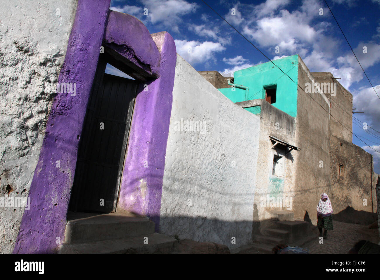 Una donna a piedi nella parte vecchia della città di Harar , Etiopia , con la sua splendida architettura Foto Stock