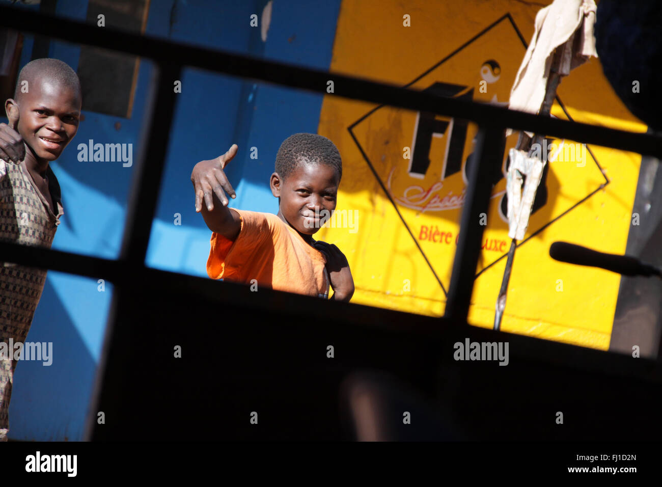 Cool bambino africano dicendo ciao nelle strade di Bovo-Dioulasso, Burkina Faso Foto Stock