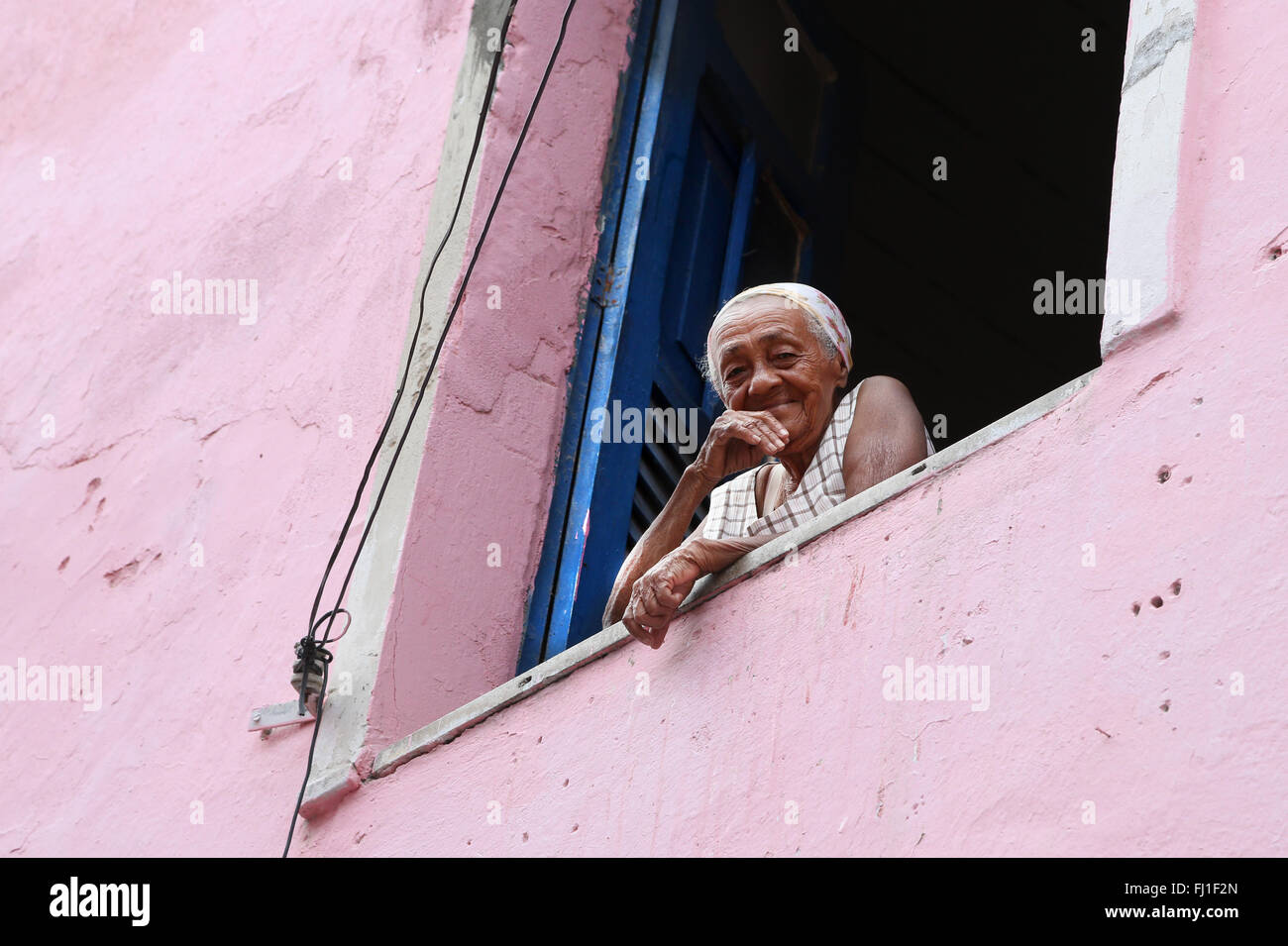 Il vecchio donna al suo balcone nella sua casa a Salvador de Bahia, Brasile Foto Stock