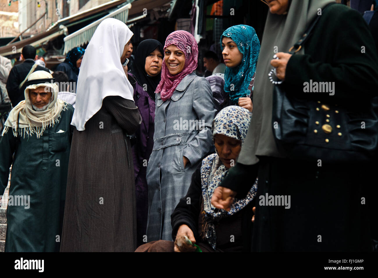 Bella sorridente donna araba con il hijab in mezzo alla folla alla porta di Damasco , Gerusalemme la città vecchia , Israele Foto Stock