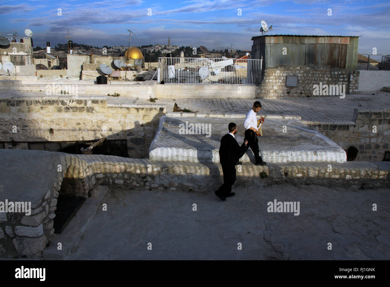 Due uomini ebrei a piedi dal tramonto sui tetti di Gerusalemme la città vecchia , Moschea di Al-Aqsa in distanza Foto Stock