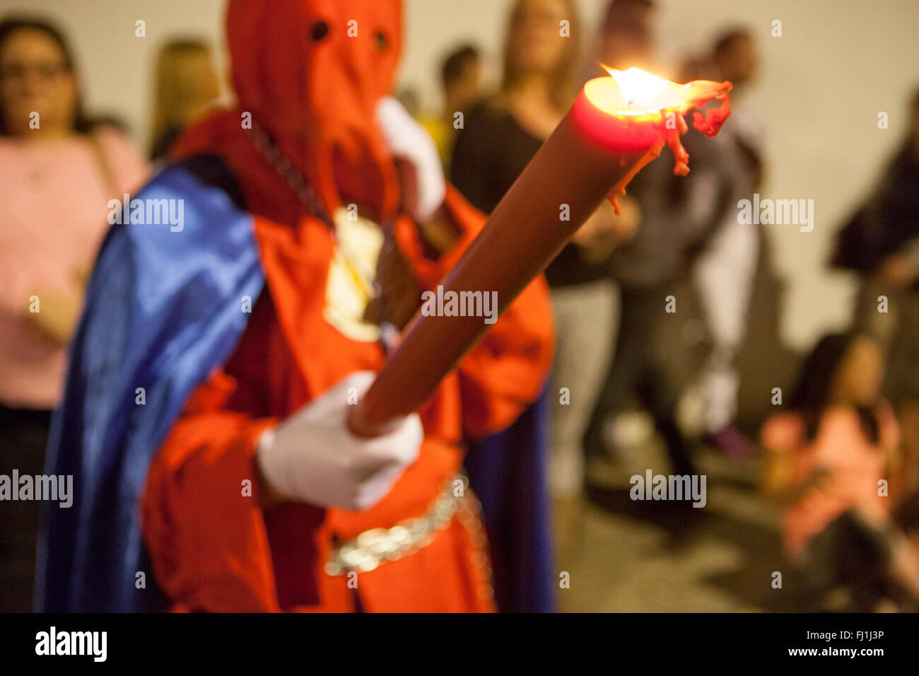 Bearer o nazareno azienda grande candela alla Settimana Santa processione, Spagna Foto Stock