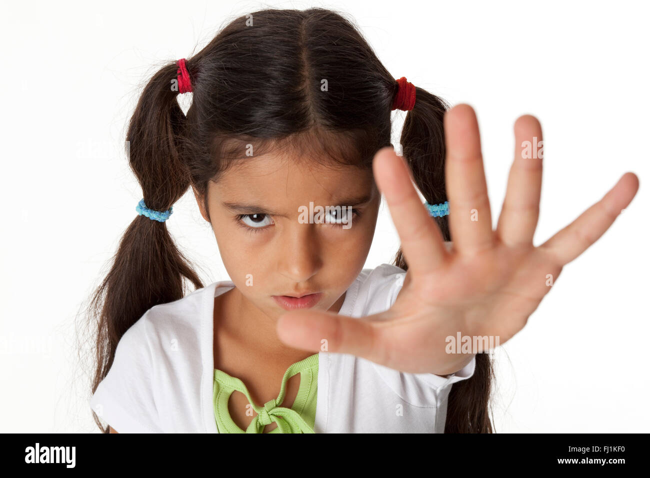 Bambina è fa un gesto di arresto con la sua mano su sfondo bianco Foto Stock