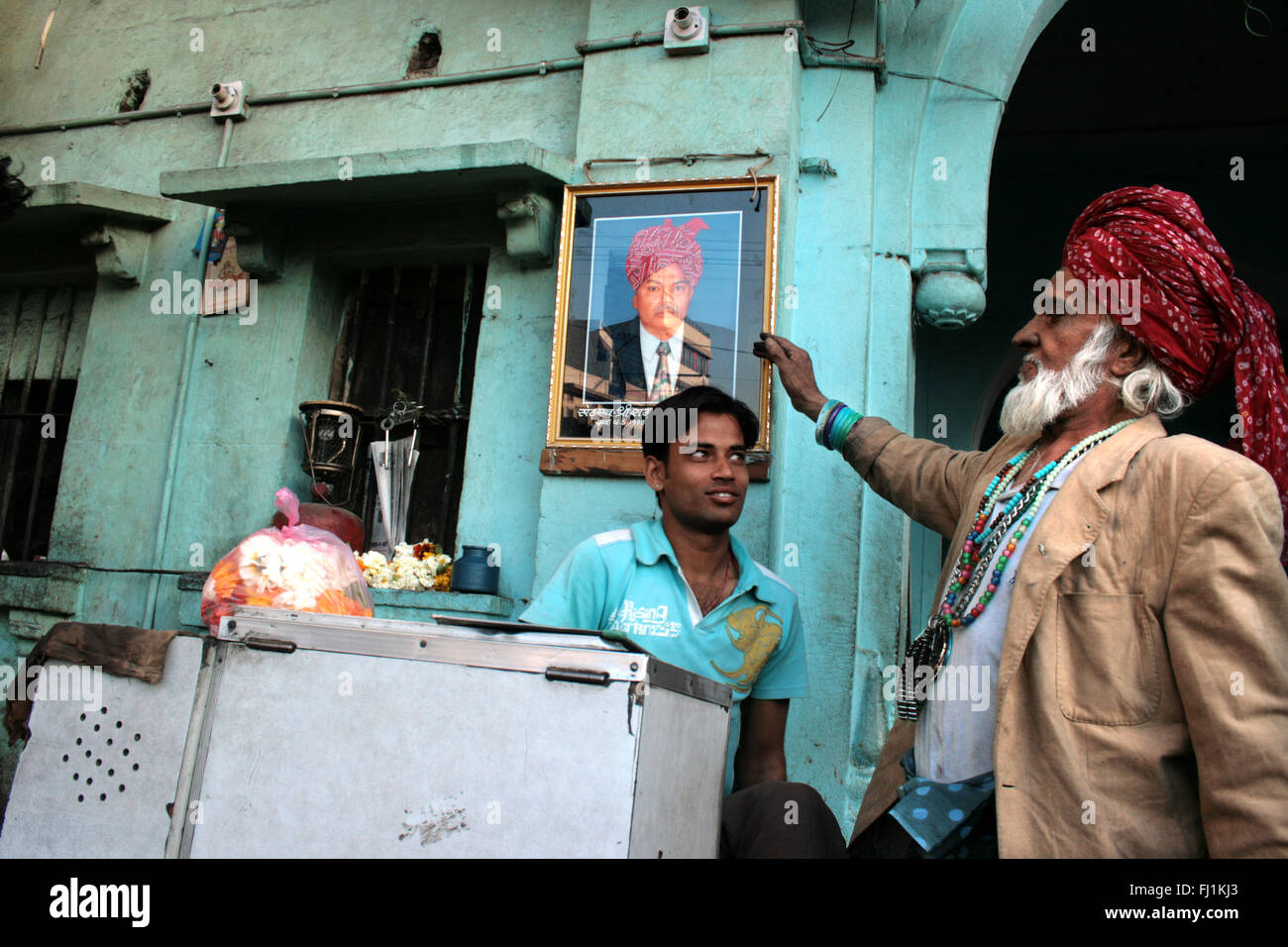 Rajasthani uomo con turbante mostra ritratto di padre in Jodhpur, India Foto Stock
