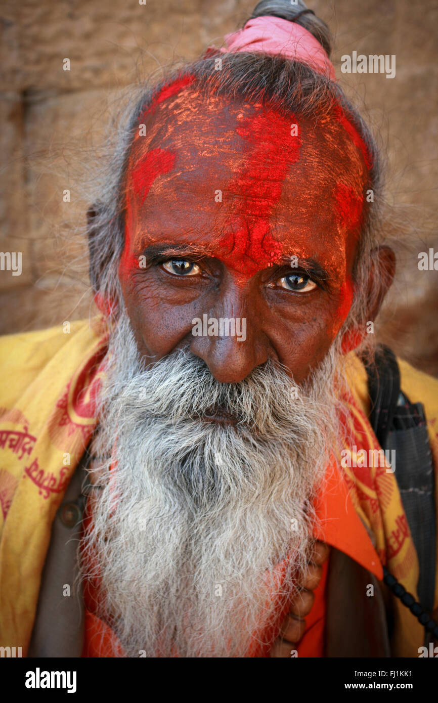 Sante indù sadhu uomo con la faccia coperta dalla polvere rossa in Jaisalmer , India Foto Stock
