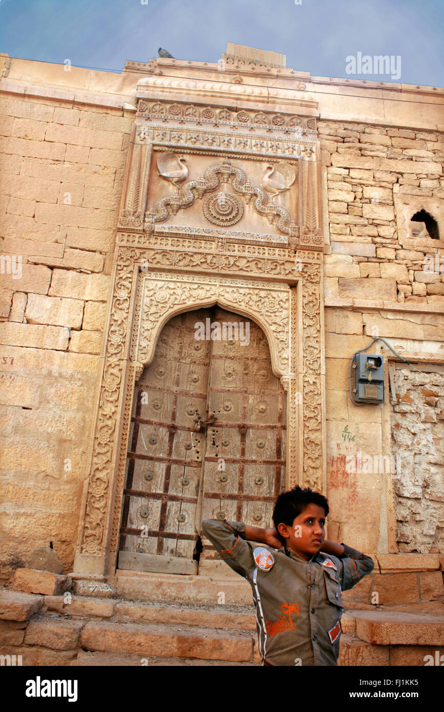 Il ragazzo si trova all'ingresso di un haveli in Jaisalmer , India Foto Stock