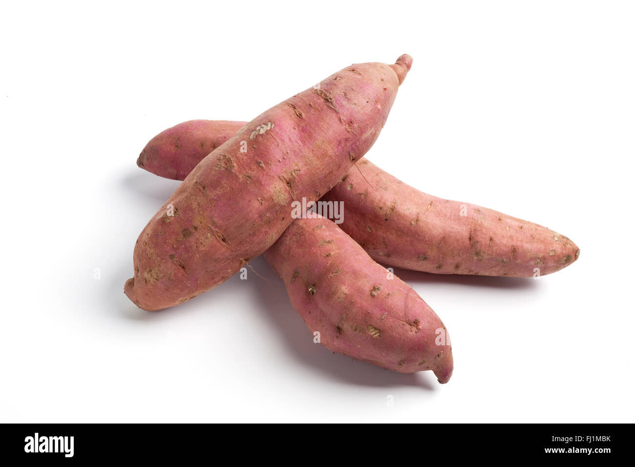 Crudo fresco patate dolci su sfondo bianco Foto Stock
