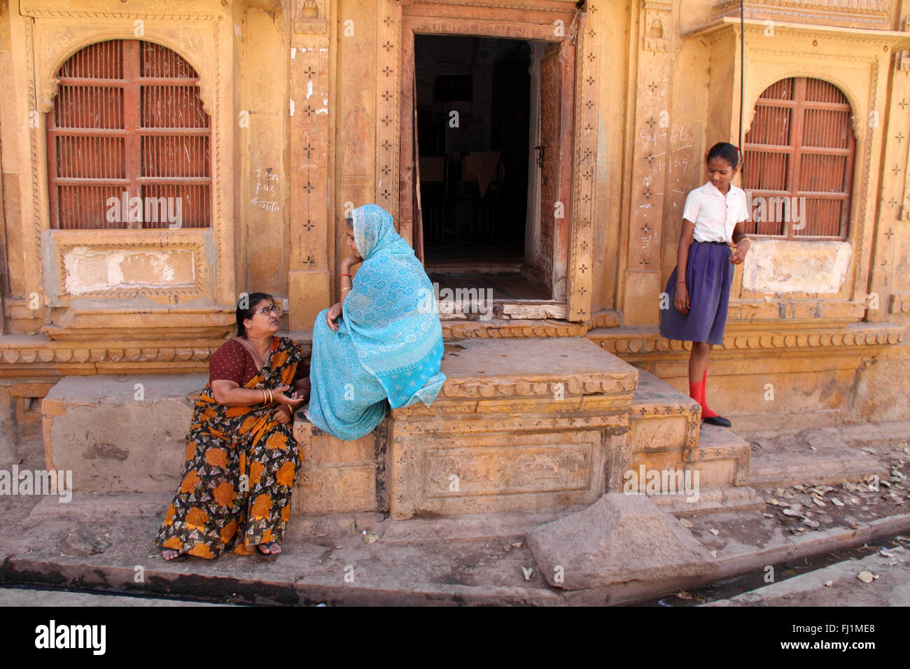 Le donne sono la discussione all'entrata di haveli / casa con architettura tradizionale in Jaisalmer , Rajasthan, India Foto Stock