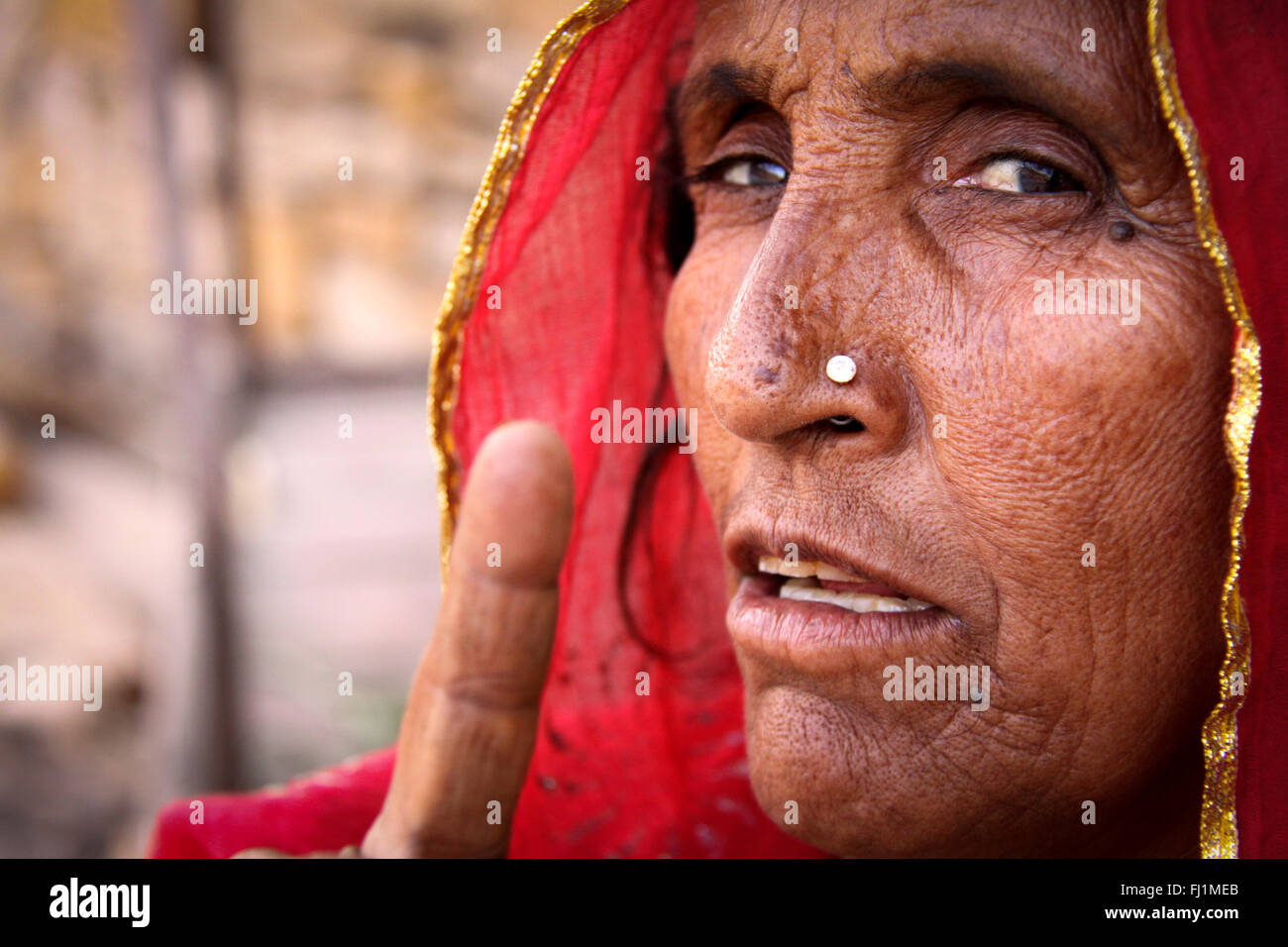 Rajasthani donna con red saree e naso anello mostra il dito di una mano per fotocamera con una forte espressione sul suo volto , Jaisalmer , India Foto Stock